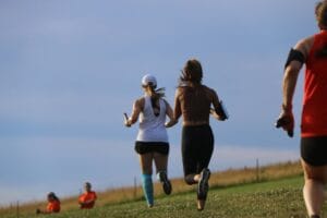 a group of people running on a grass field